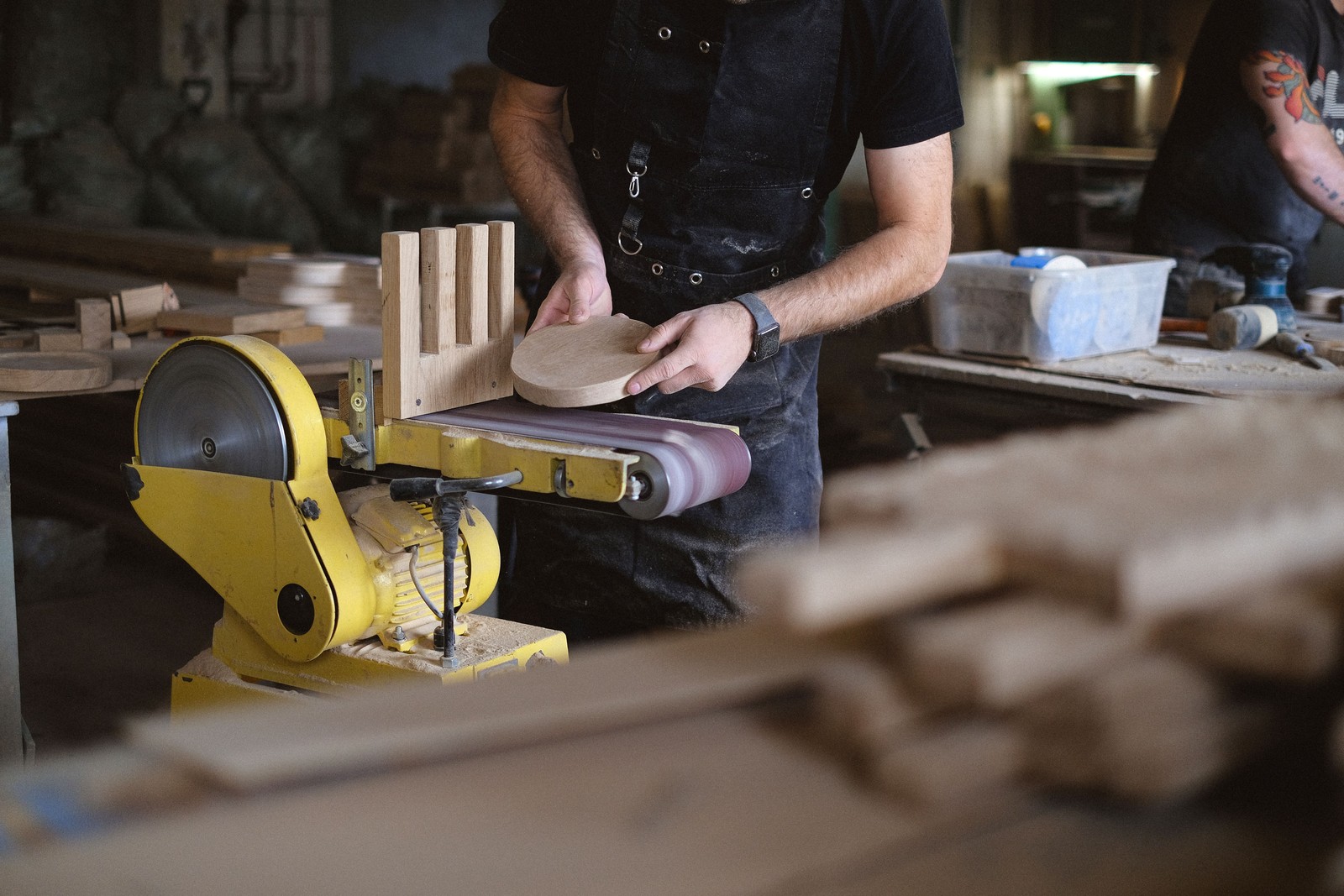 A maker sanding a wooden piece in the San Antonio workshop